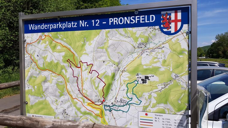 Ein Wanderschilder mit verschiedenen Routen in der Natur. Zu sehen ist der Wanderparkplatz Nr. 12 in Pronsfeld.