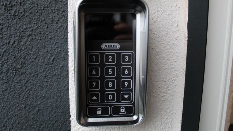 Ein moderner Code-Schloss mit einer digitalen Tastatur an einer Wand. Es bietet eine sichere Möglichkeit, einen Eingang zu steuern.