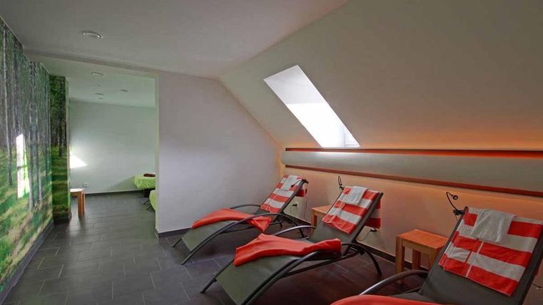 Ein gemütlicher Ruheraum mit Liegen und sanften Farben. Die Lichtverhältnisse sind angenehm und schaffen eine entspannte Atmosphäre.