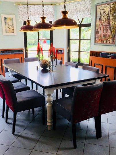 Ein eleganter Essbereich mit einem großen Tisch und bequemen Stühlen. Der Raum ist gut beleuchtet und hat eine gemütliche Atmosphäre.