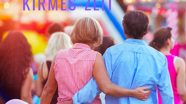 Ein Paar geht Hand in Hand über den Jahrmarkt. Bunte Lichter und Feststimmung umgeben sie.