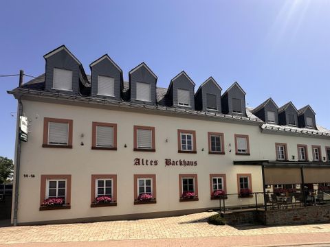 A historic building named "Old Brewery". The facade is light and has several windows as well as flower boxes.