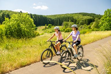 Zwei Radfahrerinnen auf dem Eifel-Ardennen-Radweg im Alfbachtal