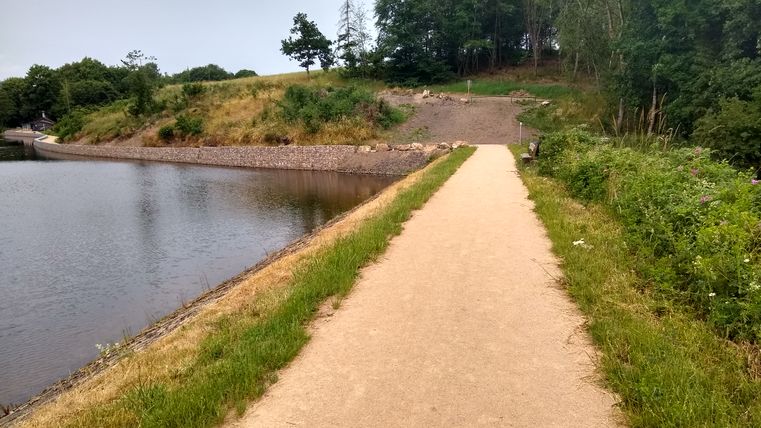 Ein sandiger, steiniger Fußweg neben dem Stausee