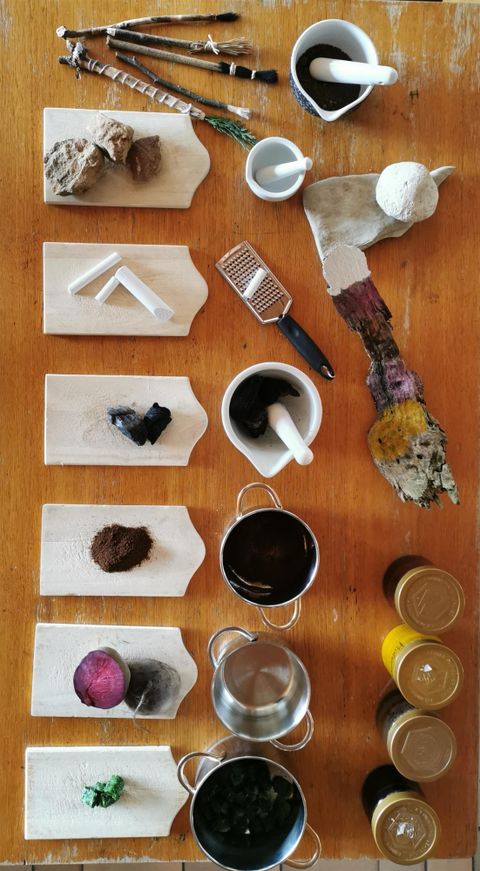 Eine Sammlung von verschiedenen Zutaten und Utensilien auf einer Holzplatte. Die Gegenstände sind ordentlich angeordnet, darunter Pulver, Behälter und Werkzeuge.