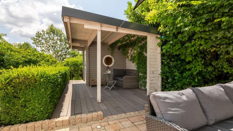 Eine gemütliche Terrasse mit Sitzgelegenheiten und vielen Pflanzen. Der Bereich ist hell und einladend, ideal für entspannte Stunden im Freien.