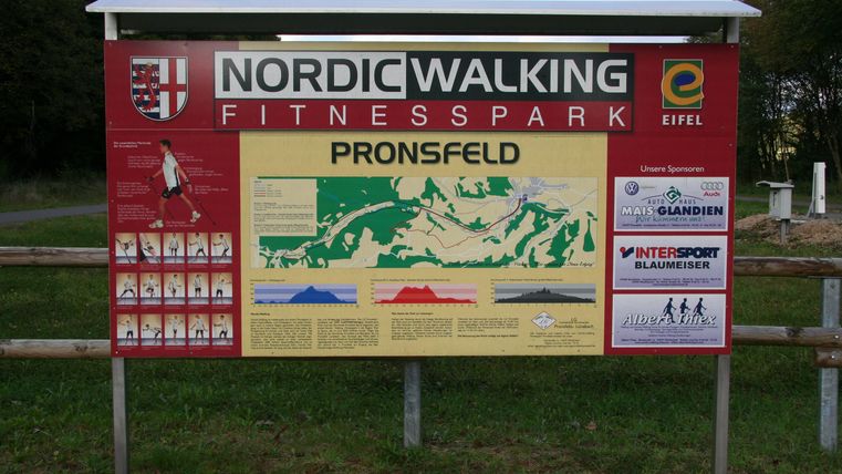 Ein Informationsschild für den Nordic Walking Fitnesspark in Pronsfeld. Es zeigt Karten und Informationen über die verfügbaren Wanderwege.
