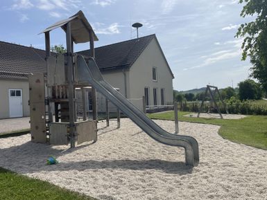 Spielturm mit Rutsche für Kinder, auf einem Sandplatz