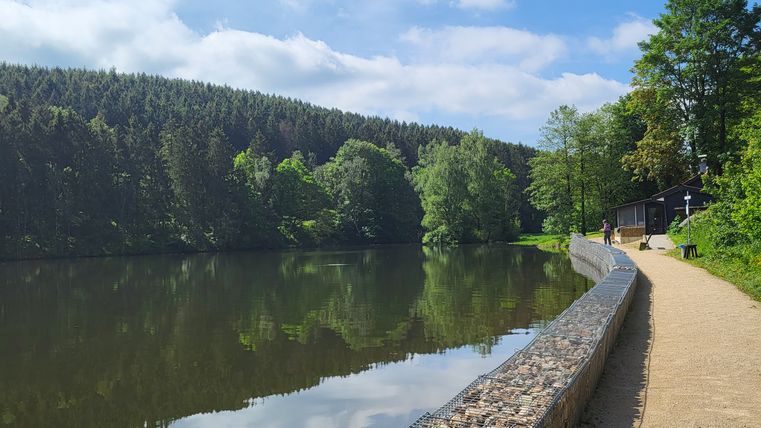 Ein Fußweg mit Gabionen unmittelbar neben dem Stausee